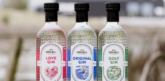 Bottles of Eden Mill's core gin range stand on a wall including Eden Mill Love Gin, Eden Mill Original Gin and Eden Mill Golf Gin.