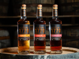 Glasgow 1770 whisky experiments with wine casks Bottles of Glasgow 1770 Small Batch Series Wine Cask editions including Constantia Wine Cask Matured, Syrah Wine Cask Matured and Pineau des Charentes Wine Cask Matured. All three bottles stand on top of a wooden barrel.