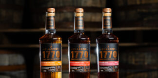 Bottles of Glasgow 1770 Small Batch Series Wine Cask editions including Constantia Wine Cask Matured, Syrah Wine Cask Matured and Pineau des Charentes Wine Cask Matured. All three bottles stand on top of a wooden barrel.