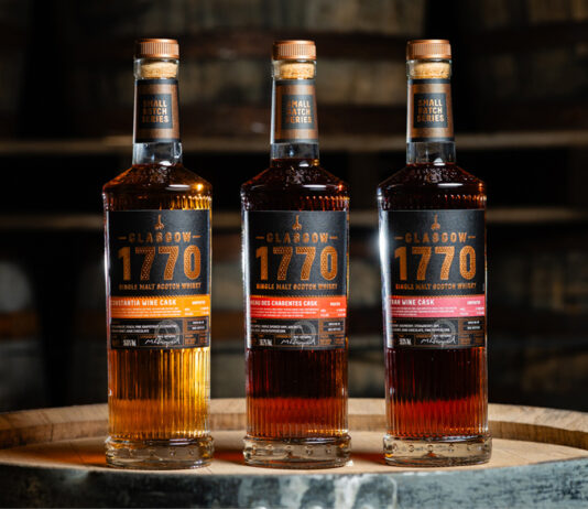 Glasgow 1770 whisky experiments with wine casks Bottles of Glasgow 1770 Small Batch Series Wine Cask editions including Constantia Wine Cask Matured, Syrah Wine Cask Matured and Pineau des Charentes Wine Cask Matured. All three bottles stand on top of a wooden barrel.