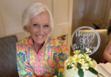 TV personality and baker Mary Berry sits at a table with the 90th Birthday cake that Finsbury Food Group had made for her.