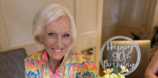 TV personality and baker Mary Berry sits at a table with the 90th Birthday cake that Finsbury Food Group had made for her.