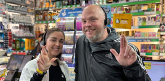 Natalie and Martin Lightfoot stand inside their store Londis Solo Convenience in Baillieston with crossed fingers to mimic the National Lottery mascot.