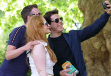 A Tom Cruise lookalike takes a selfie with people in a London park whilst holding a packet of Quorn Cocktail Sausages.