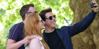 A Tom Cruise lookalike takes a selfie with people in a London park whilst holding a packet of Quorn Cocktail Sausages.