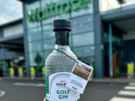 Eden Mill secures first UK-wide listing in Waitrose A person is holding a bottle of Eden Mill Golf Gin in front of a Waitrose supermarket store.