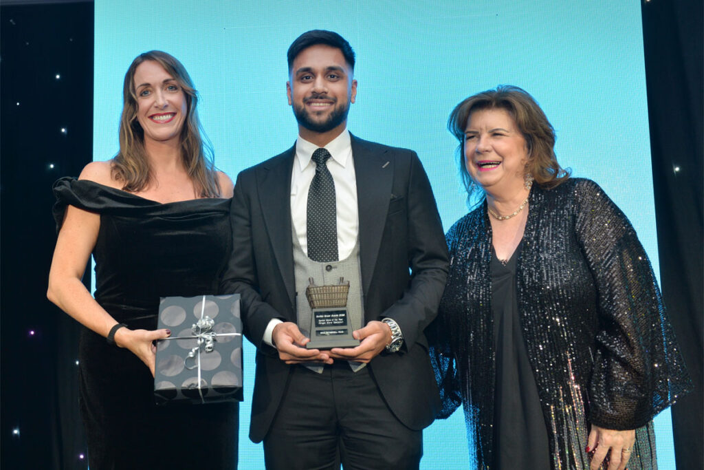 Three people standing on a stage to accept an award at the Scottish Grocer Awards 2024.