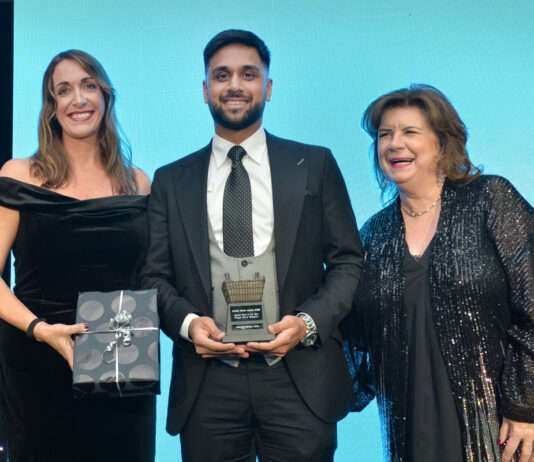 Three people standing on a stage to accept an award at the Scottish Grocer Awards 2024.