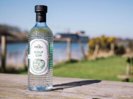 Eden Mill extends partnership with Genesis Scottish Open as Official Gin A bottle of Eden Mill Golf Gin stands on a wooden table with greenery and water in the background.