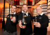 English rugby players James Haskell, Mike Tindall and broadcaster Alex Payne stand in a distillery holding glasses as Haskell holds a bottle of Rémy Martin VSOP as part of a campaign for the brand.