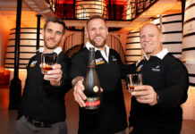 English rugby players James Haskell, Mike Tindall and broadcaster Alex Payne stand in a distillery holding glasses as Haskell holds a bottle of Rémy Martin VSOP as part of a campaign for the brand.