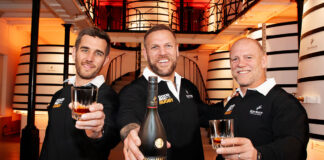 English rugby players James Haskell, Mike Tindall and broadcaster Alex Payne stand in a distillery holding glasses as Haskell holds a bottle of Rémy Martin VSOP as part of a campaign for the brand.