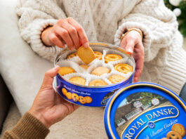 Fox’s Burton’s acquires Royal Dansk Swedish biscuits A person lifts biscuits out from a blue Royal Dansk biscuit tin.