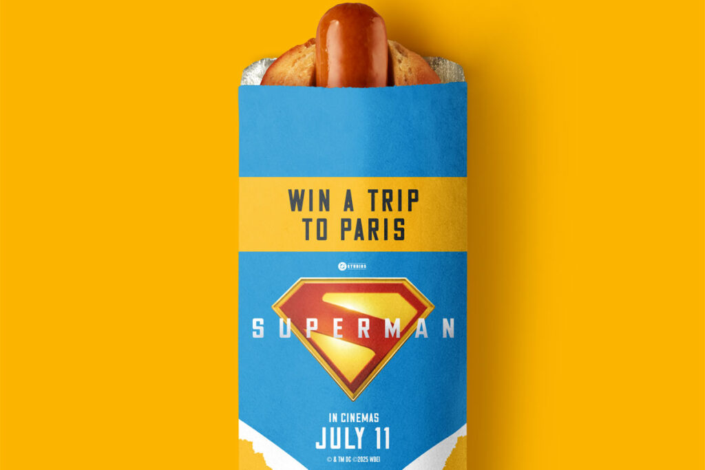 Rollover Hot Dog with branding on the top of it featuring Superman (2025) offering consumers the chance to win a trip to Paris.