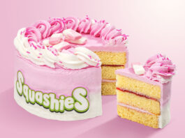 Swizzels’ first Squashies Celebration Cake heads to Tesco stores A Squashies Strawberries & Cream Celebration Cake with a slice taken out of the cake against a pink background.