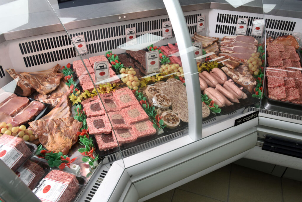 Butchery counter with a range of meat products lined up.