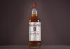 A bottle of Falkland Whisky is against a dark background.