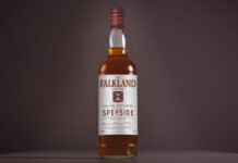 A bottle of Falkland Whisky is against a dark background.