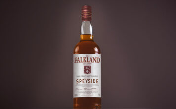 A bottle of Falkland Whisky is against a dark background.
