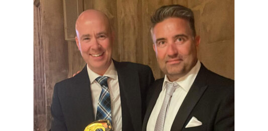 Craig Brown (left) and Chris Miller (right) stand together holding Grocer Gold award.