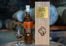 A bottle of Glen Scotia 25 Year Old stands next to its wooden box package and a nosing glass with the Glen Scotia logo on it – the bottle was gifted to King Charles III.