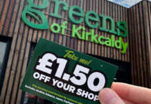 A person holds a £1.50 off voucher for use in Greens Retail stores outside of Greens of Kirkcaldy.