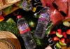 Bottles of Highland Spring flavours water at a picnic with food spilled out onto a patch of grass.