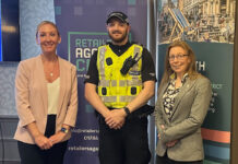 A police officer stands between two women with signage behind them for Retailers Against Crime and Go Forth Stirling.