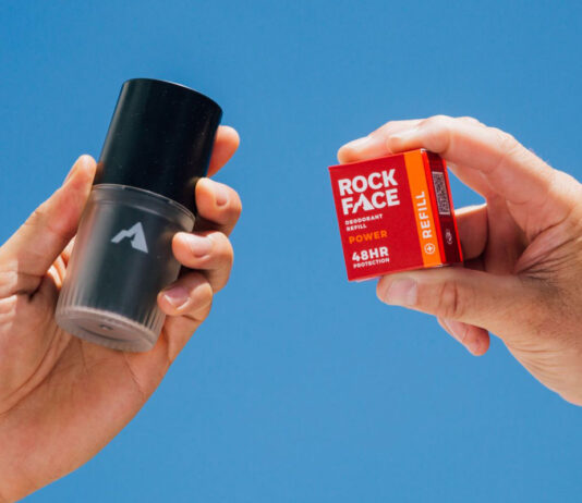 A person holds a Rock Face Deodorant Refillable container with a Rock Face Refillable Deodorant Power pack in the other hand.