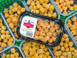 Punnets of Scotty Brand Golden Raspberries on a store shelf.