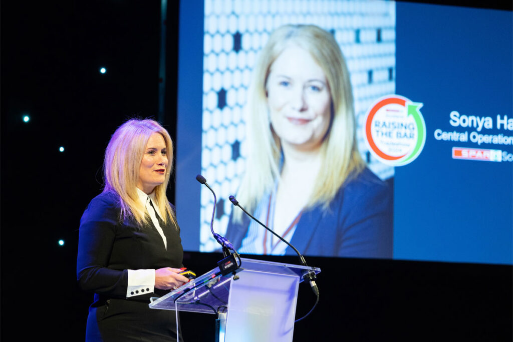Sonya Harper, chief operating officer at Spar Scotland, stands at a podium delivering a speech during the Spar Tradeshow event.