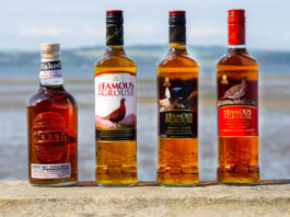 The Famous Grouse sale to William Grant & Sons is finalised Bottle of The Famous Grouse whisky and The Naked Malt are lined up on a stone wall with an ocean view behind them.