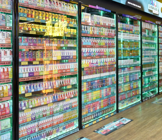 Imperial Brands urges Government to prevent disposal of refillable vapes Glass cabinet of vaping products lined up against a store wall.