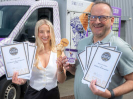 Alex and David Equi stand holding certificates for Great Taste Awards for their products as well as a commercial tub of the brand's ice cream.