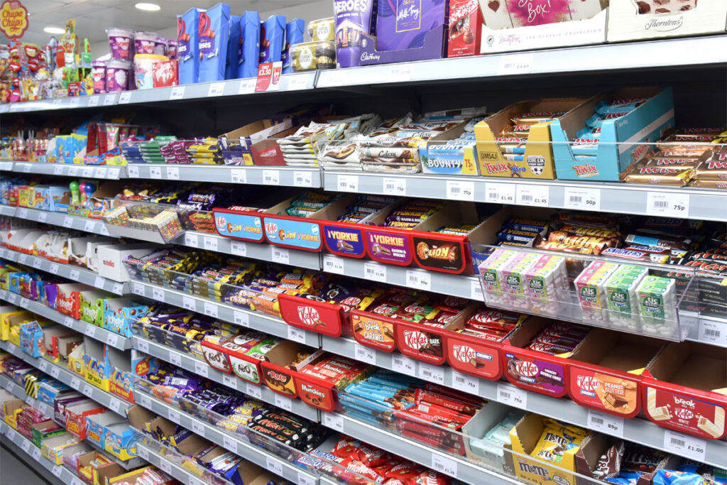 Confectionery aisle inside of a Day-Today store showcasing a vast array of chocolate bar options.