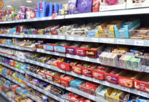 Confectionery aisle inside of a Day-Today store showcasing a vast array of chocolate bar options.