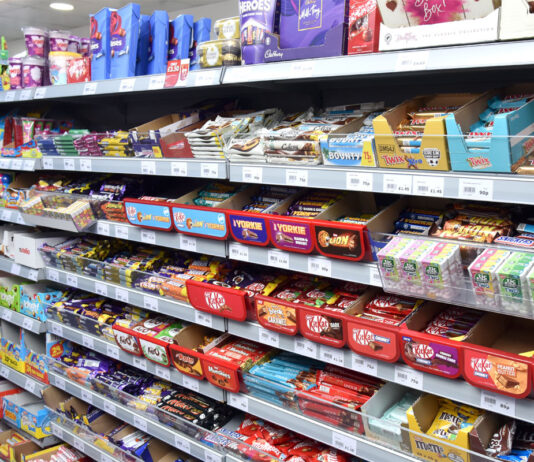 Confectionery aisle inside of a Day-Today store showcasing a vast array of chocolate bar options.