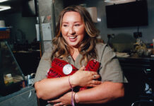 Edinburgh retailer Sophie Williams stands holding cans of Coca-Cola Zero Sugar in her arms.