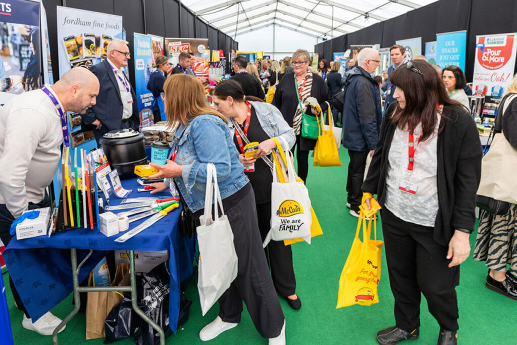 A group of people between stands at the Spar Scotland Tradeshow 2024.
