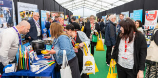 A group of people between stands at the Spar Scotland Tradeshow 2024.