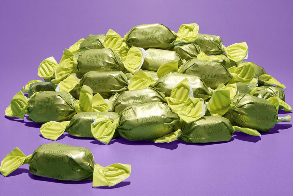 A pile of green wrapper chocolates for Quality Street boxes, the chocolate's flavour is to remain a mystery until December 2025.