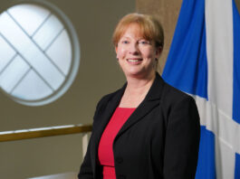Scottish budget pushed to January Scottish finance secretary Shona Robison stands in Parliament with the Scotland flag behind her.
