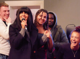 Celebrity Traitors host Claudia Winkleman fronts National Lottery campaign TV host Claudia Winkleman stands with a group of young people holding a microphone in a recording studio.