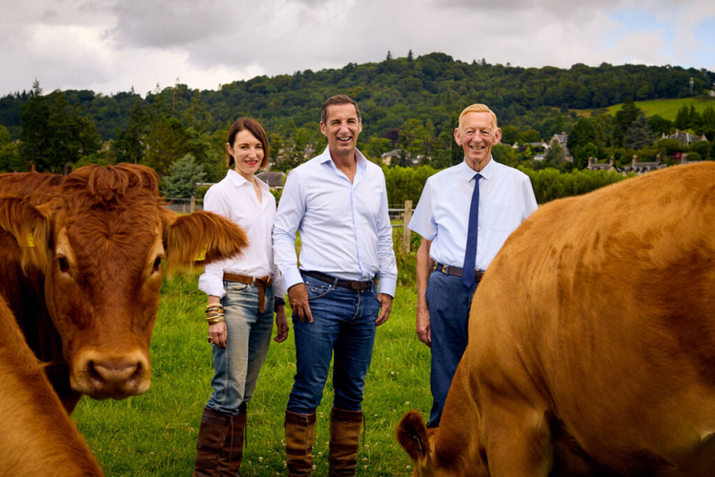 Members of the Graham's family from Graham's Family Dairy stand in a field with the family's field of cows.