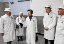 HRH Princess Anne stands in the Mackie's of Scotland factory with members of the Mackie's team.