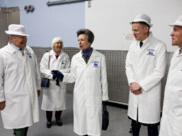 HRH Princess Anne stands in the Mackie's of Scotland factory with members of the Mackie's team.