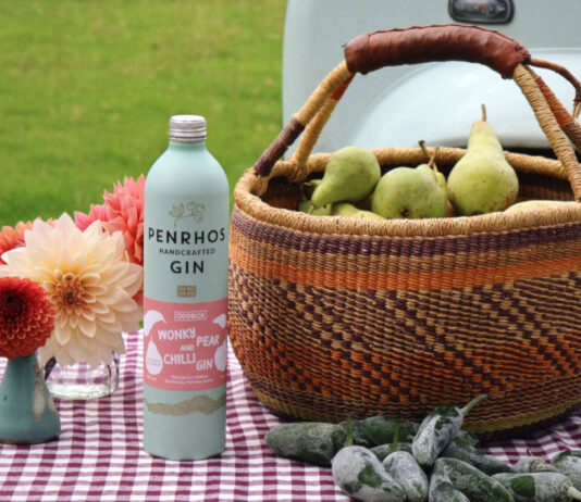 Fiery collaboration yields new Pear and Chilli Gin from Penrhos and Oddbox A bottle of Penrhos Gin Pear & Chilli stands next to a basket filled with pears and chillis in front of the basket with a gingham picnic blanket underneath it all.