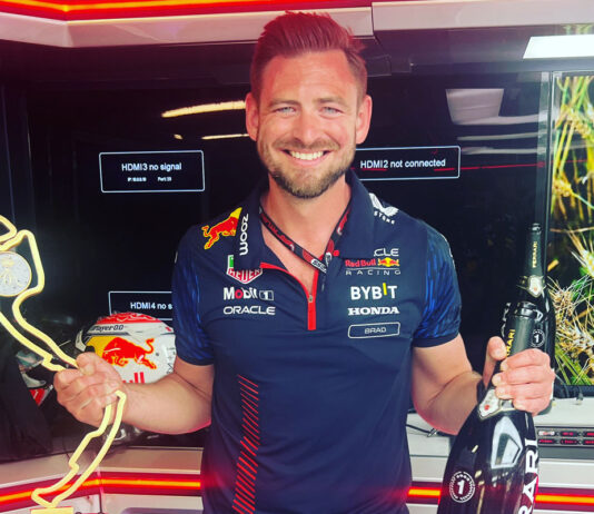 Bradley Scanes takes on director role at AG Barr Bradley Scanes, former Formula One coach, stands holding a bottle of champagne in one hand and a trophy in the other.