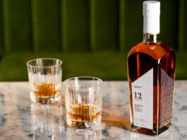 The Cairn Distillery encourages exploration with blended malt whisky range A bottle of CRN57 12 Years Old Blended Malt Scotch Whisky with two drams served in glasses next to the bottle. All of this is sitting on top of a marble tabletop.