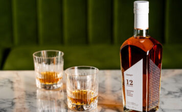 The Cairn Distillery encourages exploration with blended malt whisky range A bottle of CRN57 12 Years Old Blended Malt Scotch Whisky with two drams served in glasses next to the bottle. All of this is sitting on top of a marble tabletop.